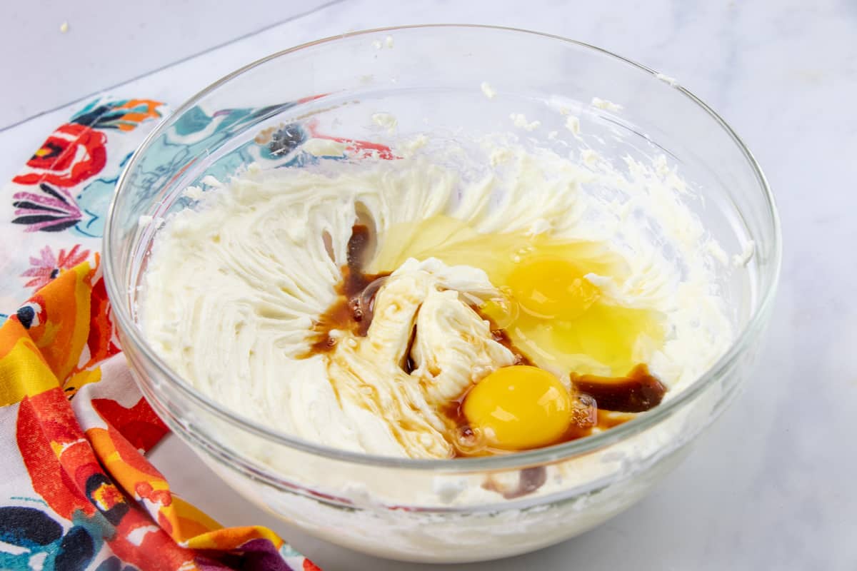 softened cream cheese, eggs, vanilla extract mixed together in a bowl.