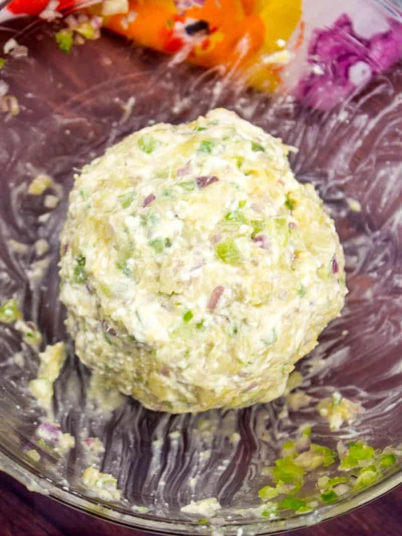 pineapple cheeseball wrapped in plastic wrap.