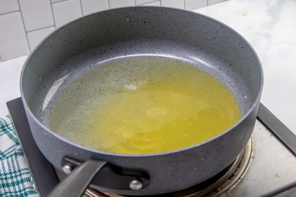 MELTED BUTTER AND OIL IN A LARGE SKILLET OVER MEDIUM HEAT