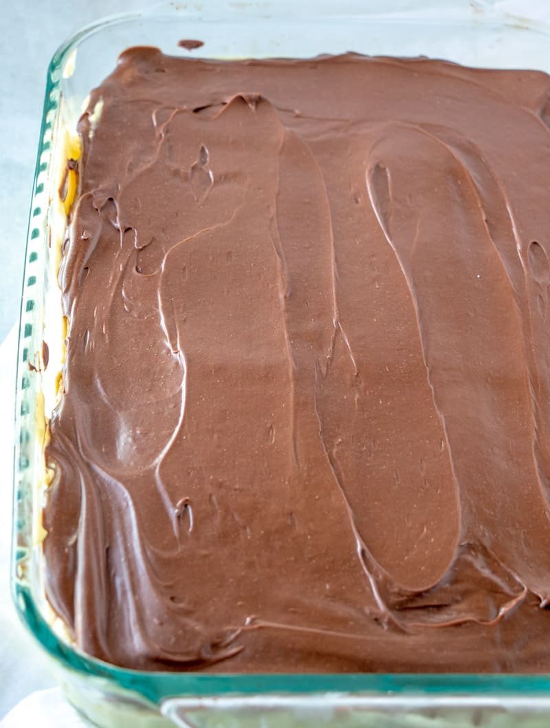 chocolate frosting spread on top of eclair cake.