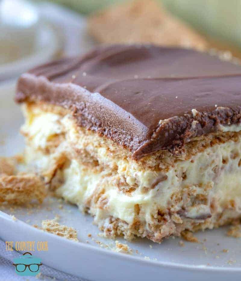 close up side photo of a slice of eclair cake on a round white plate. 