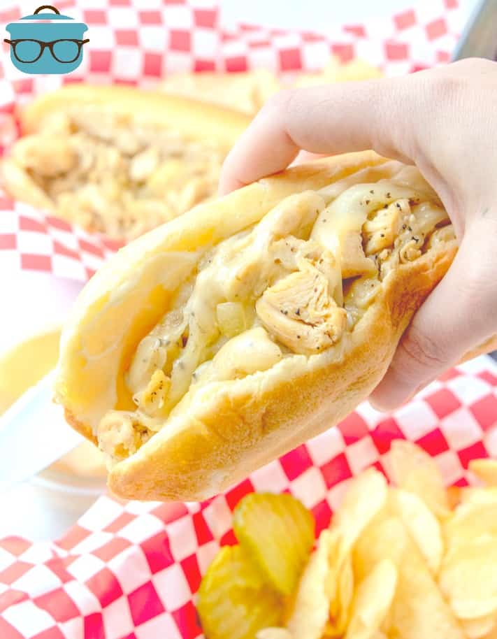 handheld, Chicken Philly Sandwich with baskets of chips in the background