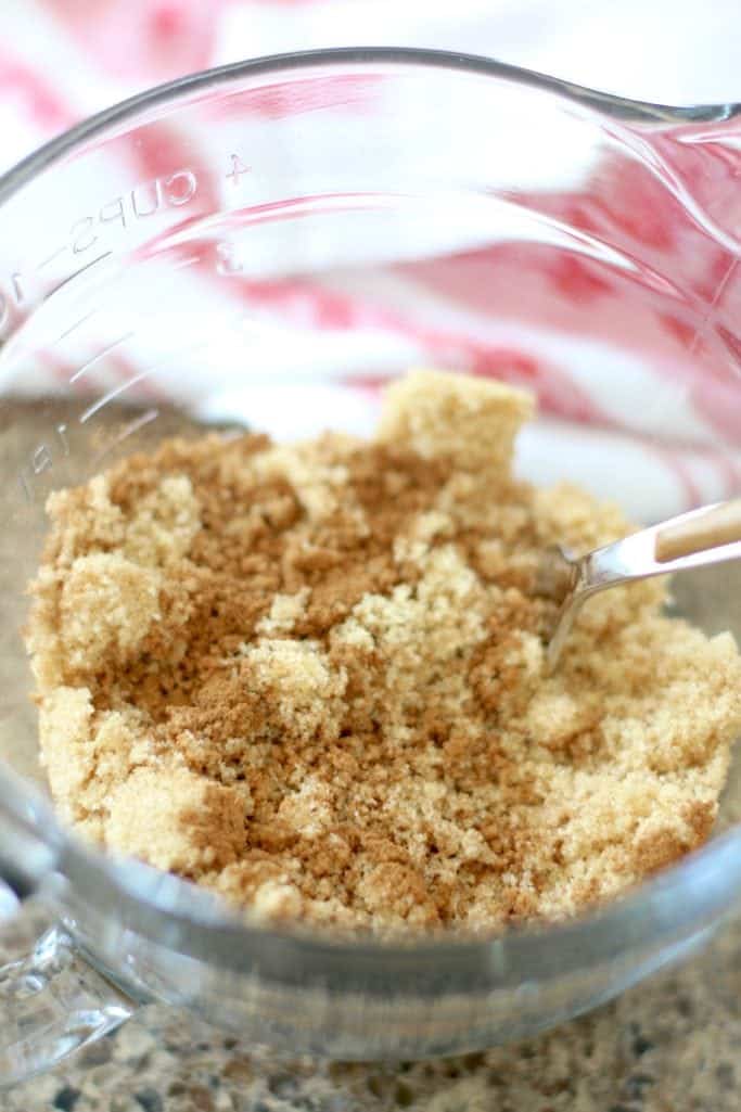 brown sugar and cinnamon mixed with a fork in a glass Pampered Chef measuring bowl
