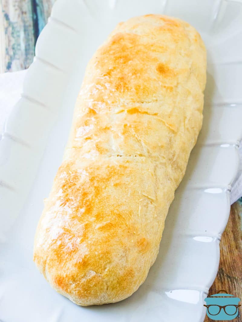 French Bread, fully baked on a white serving platter.