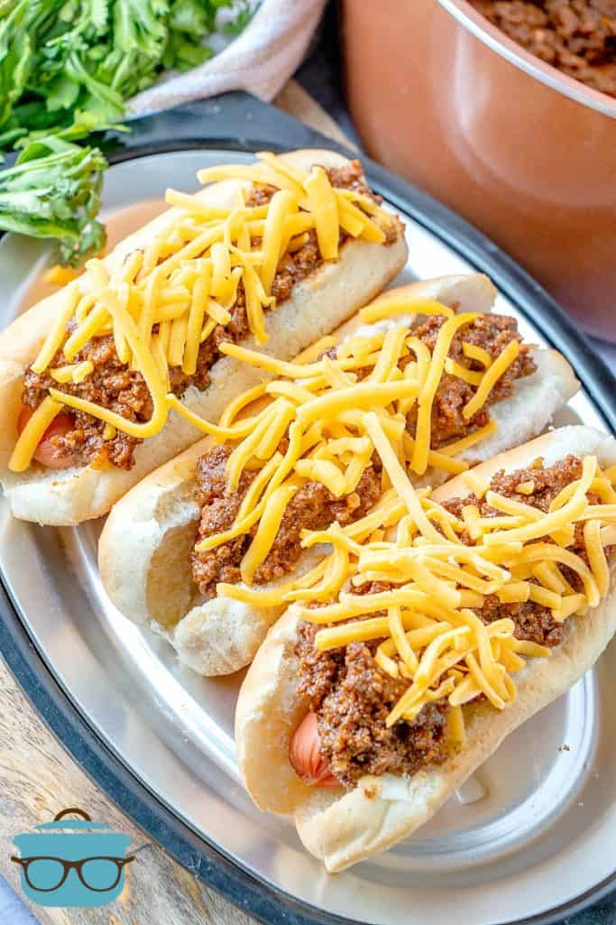 Hot Dog Chili served on hoods on bun with shredded cheddar cheese on top
