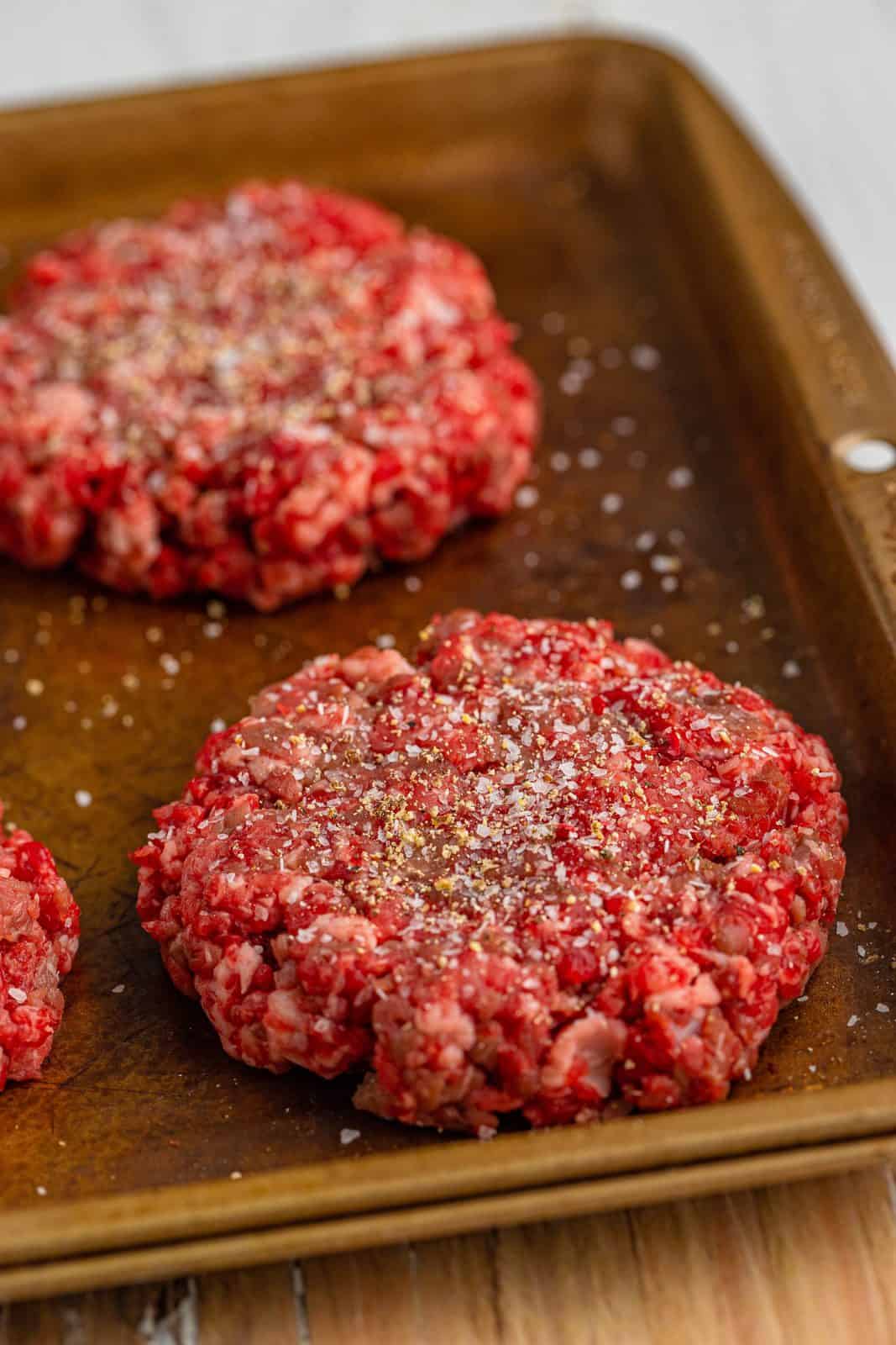 salt and pepper shown sprinkled on top of hamburger patties