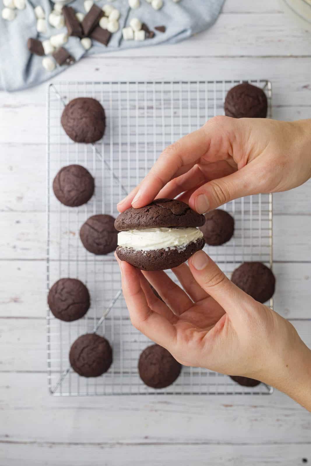 two hands holding a whoopie pie showing how to assemble the cookie. 
