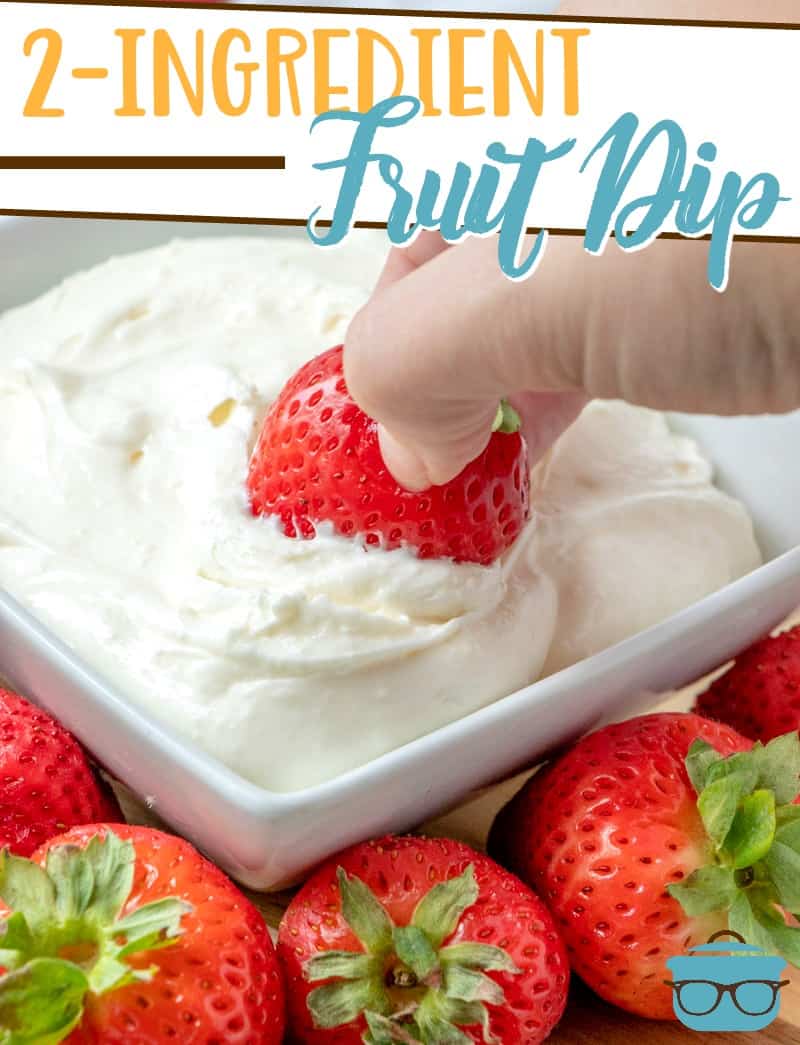 2-Ingredient Fruit Dip recipe from The Country Cook, pictured: hand holding a strawberry being tipped into smooth and creamy white fruit dip in a white bowl.