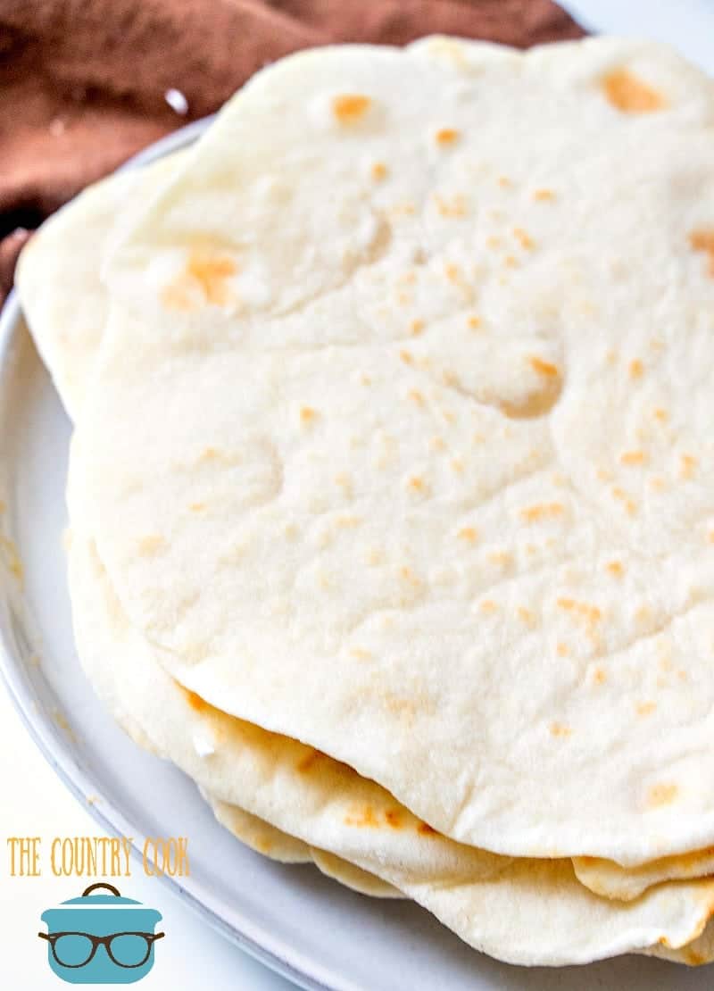 easy light and fluffy homemade flour tortillas shown close up on a plate.