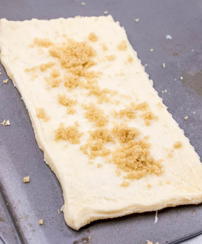 light brown sugar sprinkled on crescent roll dough.