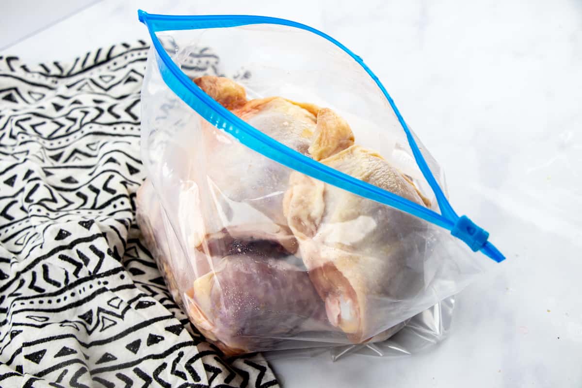 chicken parts marinating in Huli Huli chicken sauce in a ziploc bag.