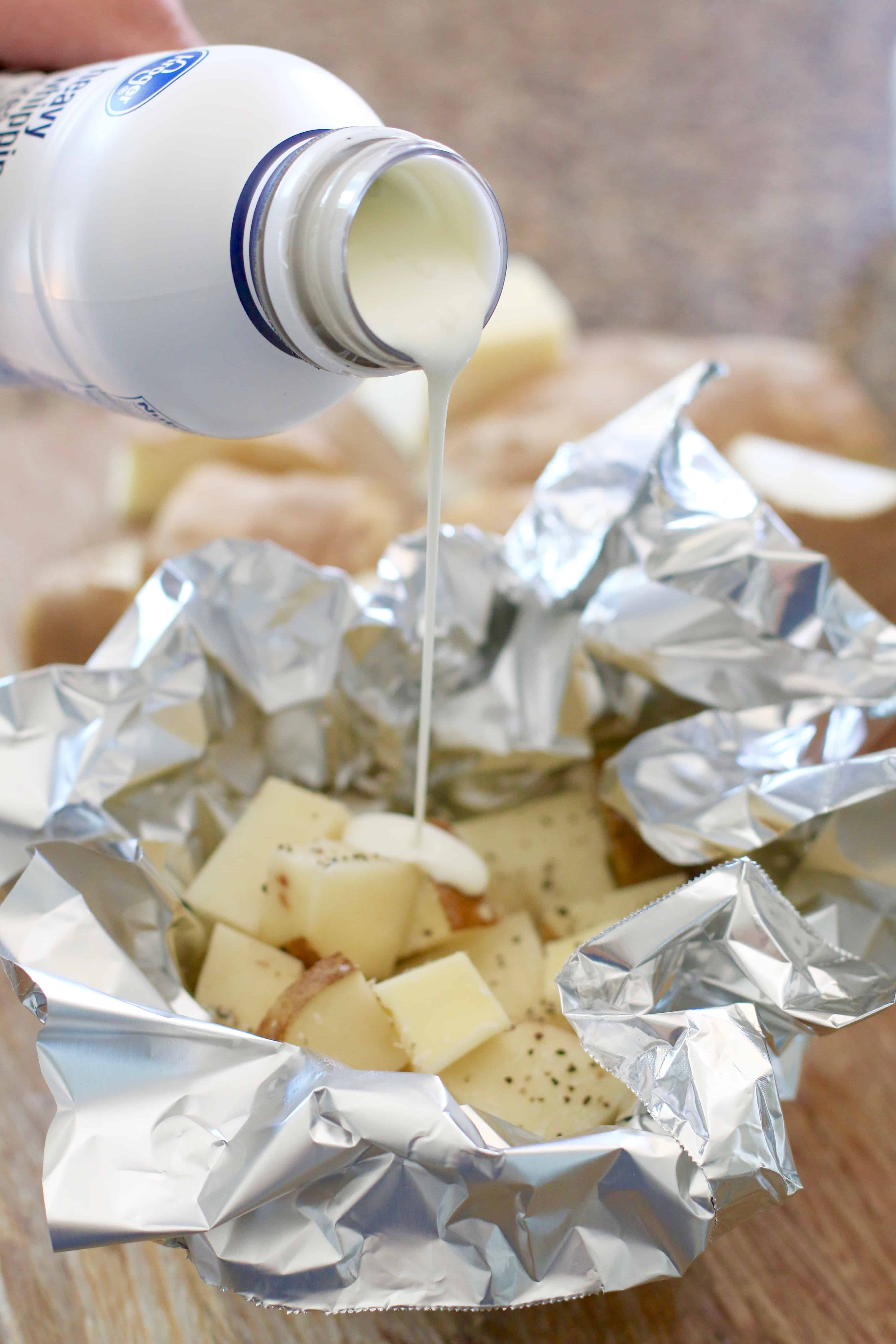 heavy cream shown being poured into  potato foil packs.