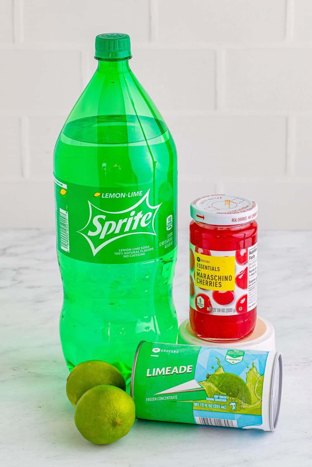 a bottle of Sprite, maraschino cherries, frozen limeade concentrate and limes. 
