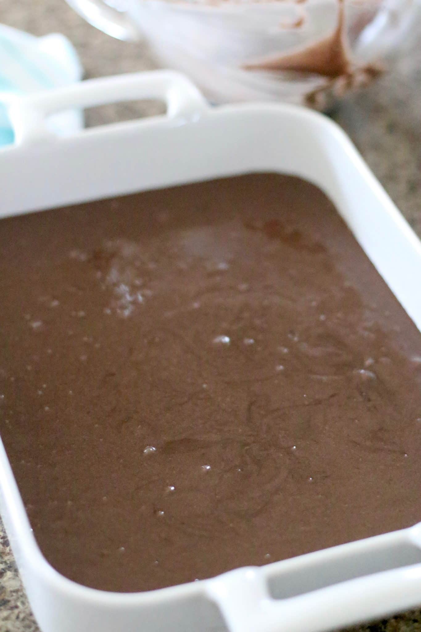 chocolate cake mix batter in a white baking dish.