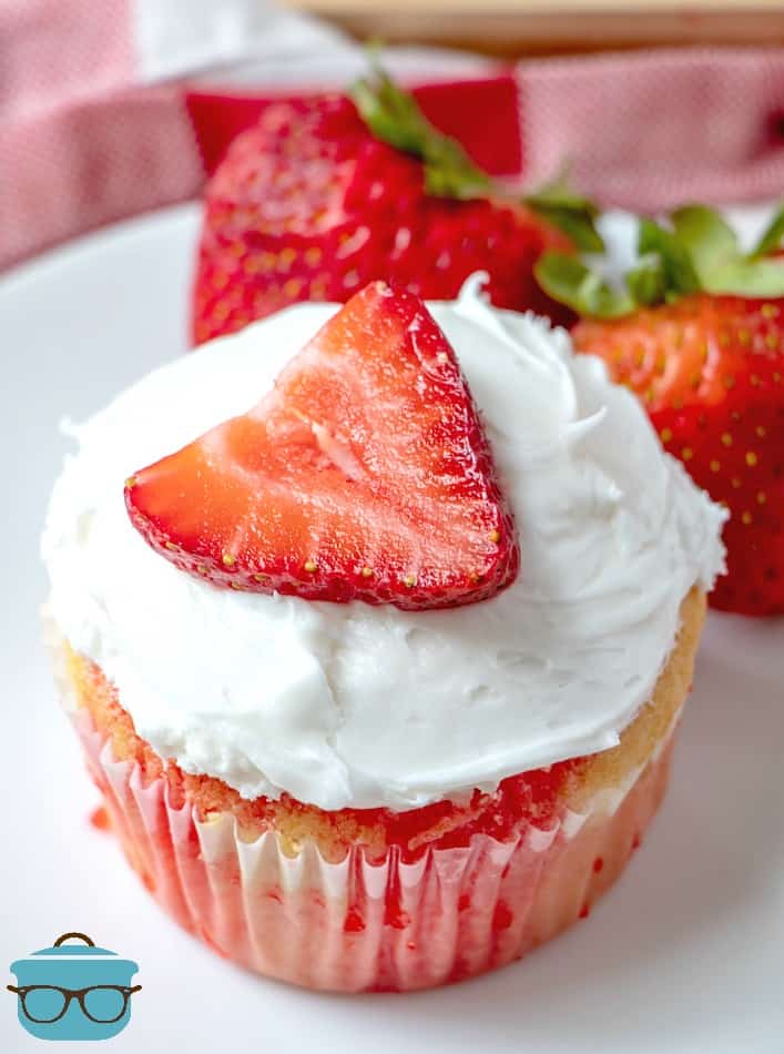 individual, strawberry jell-o poke cupcake shown on a round white plate.