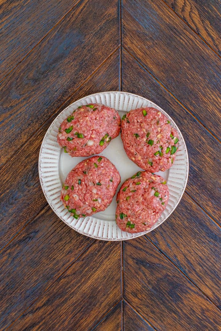four hamburger shaped patties on a white plate. 