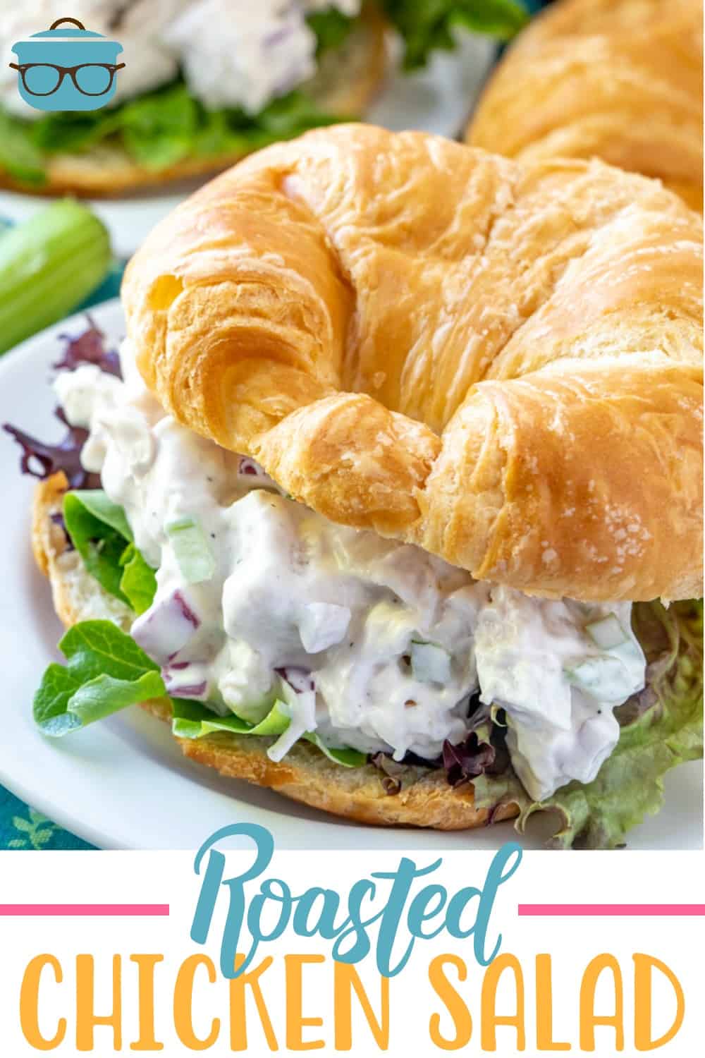 The Best Roasted Chicken Salad recipe from The Country Cook shown in a croissant with some lettuce on a round white plate.