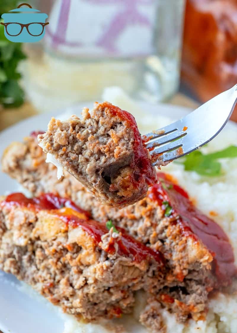 forkful, meatloaf topped with ketchup.
