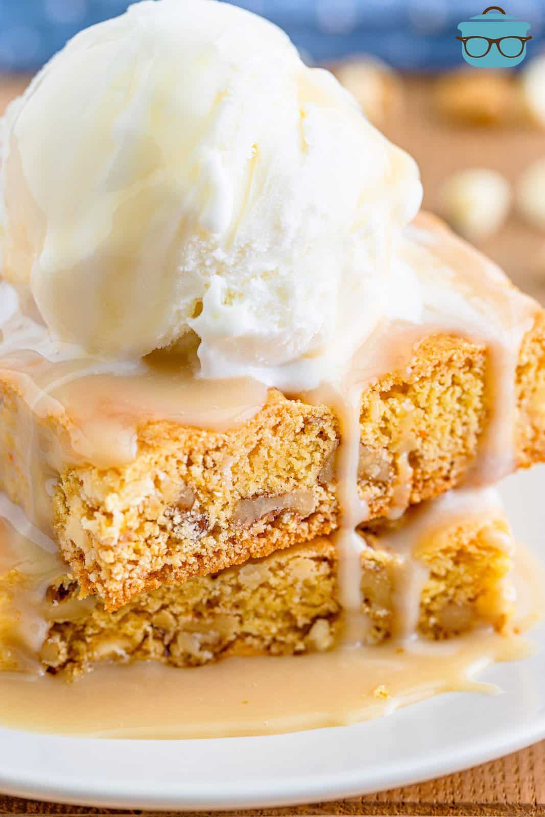 closeup photo of two slices of blondies with maple butter sauce poured on top. 