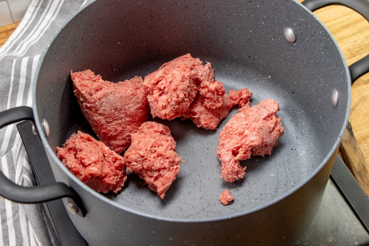 browning and crumbling ground beef in a stock pot.