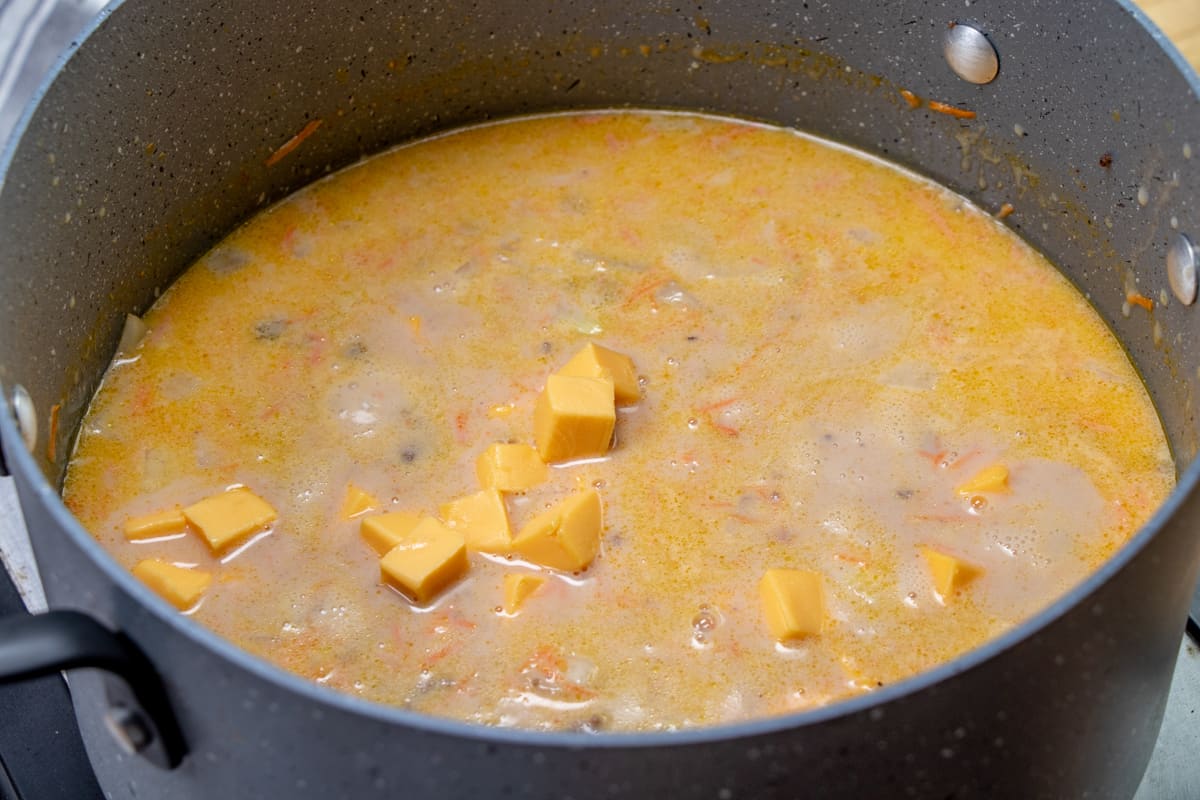adding Velveeta cheese to soup pot mixture.