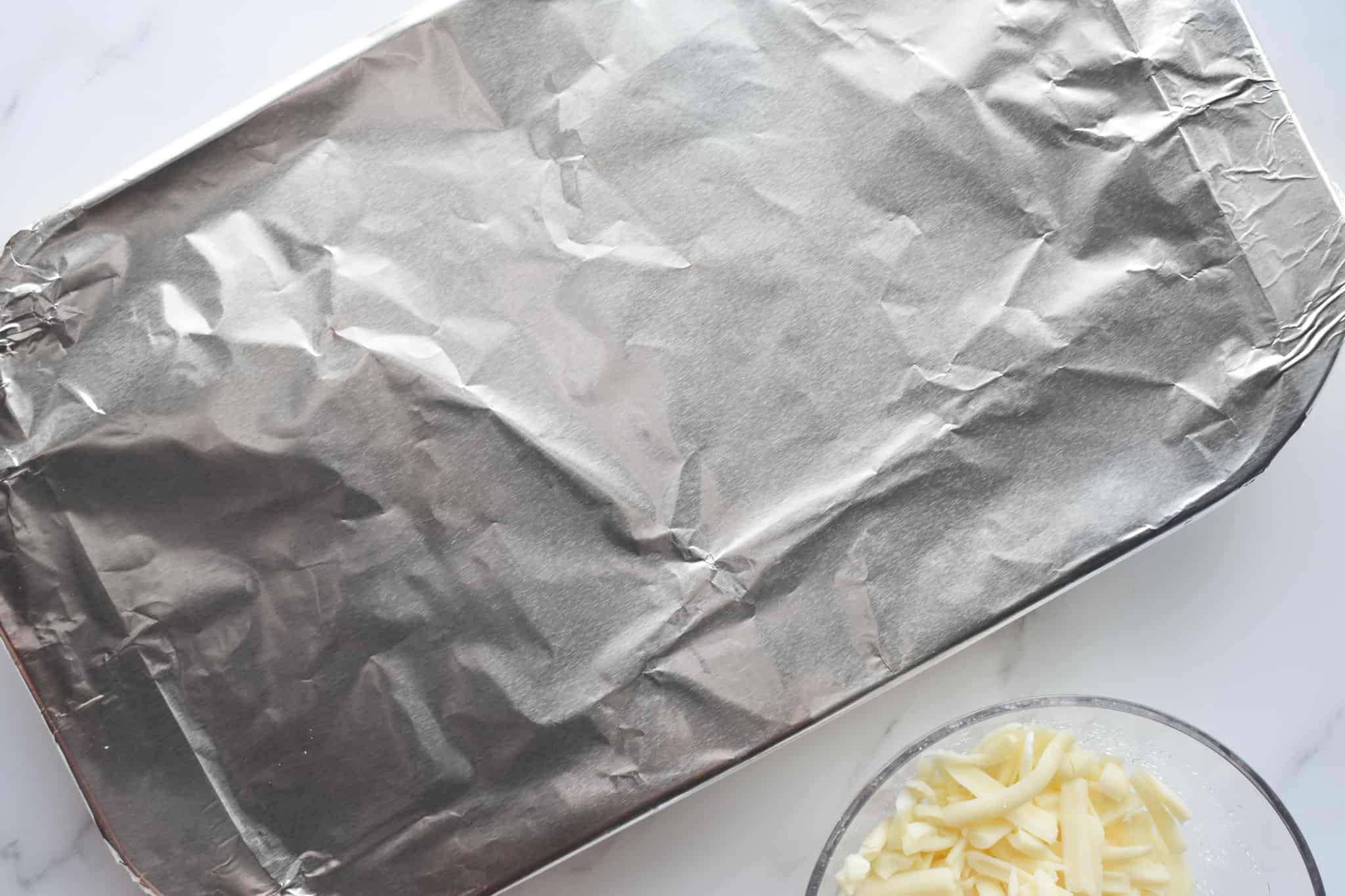 covering stuffed shells baking dish with aluminum foil.
