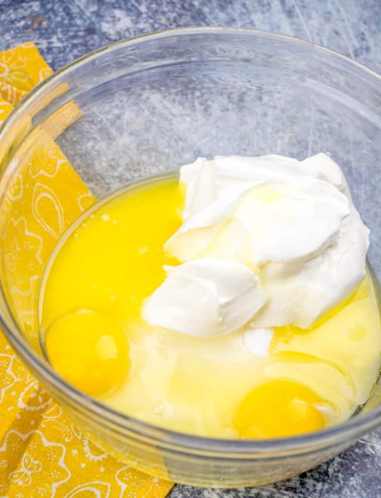 melted butter, eggs, sugar, sour cream combined in a bowl