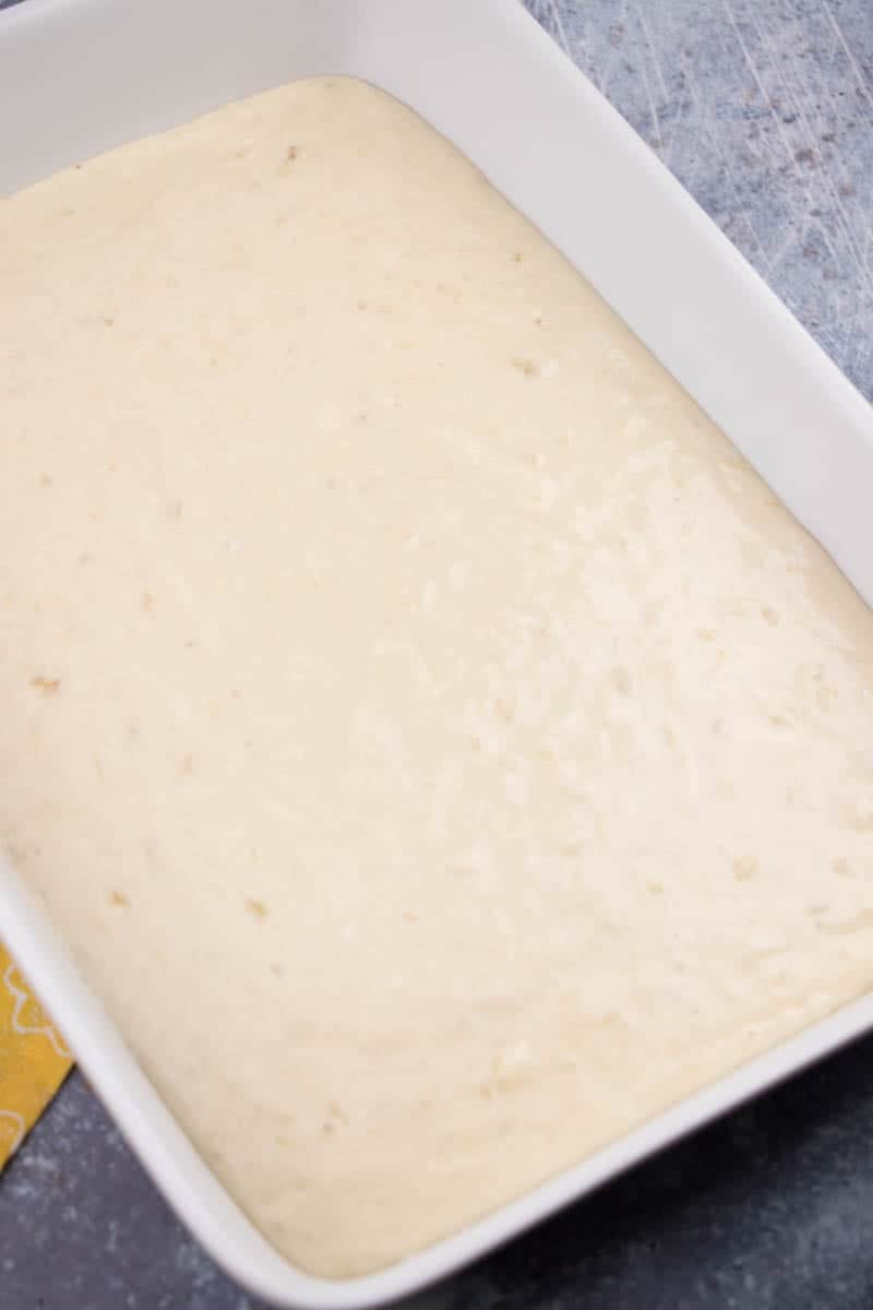 banana cake batter poured into a 9x13-inch baking dish.