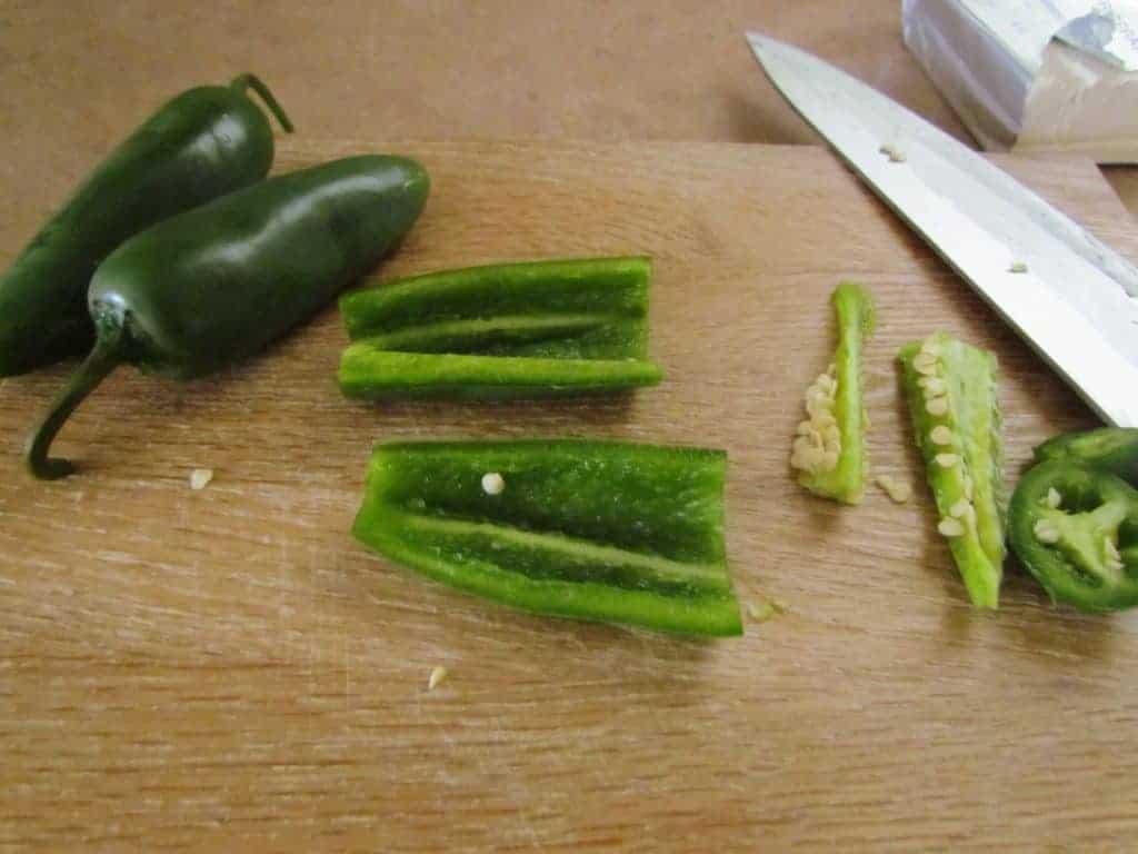 slicing and dicing jalapeños on a cutting board