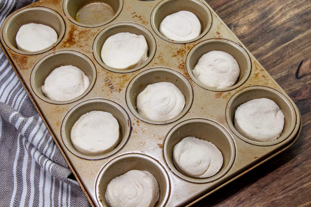 refrigerated canned biscuits individually placed in a muffin tin.