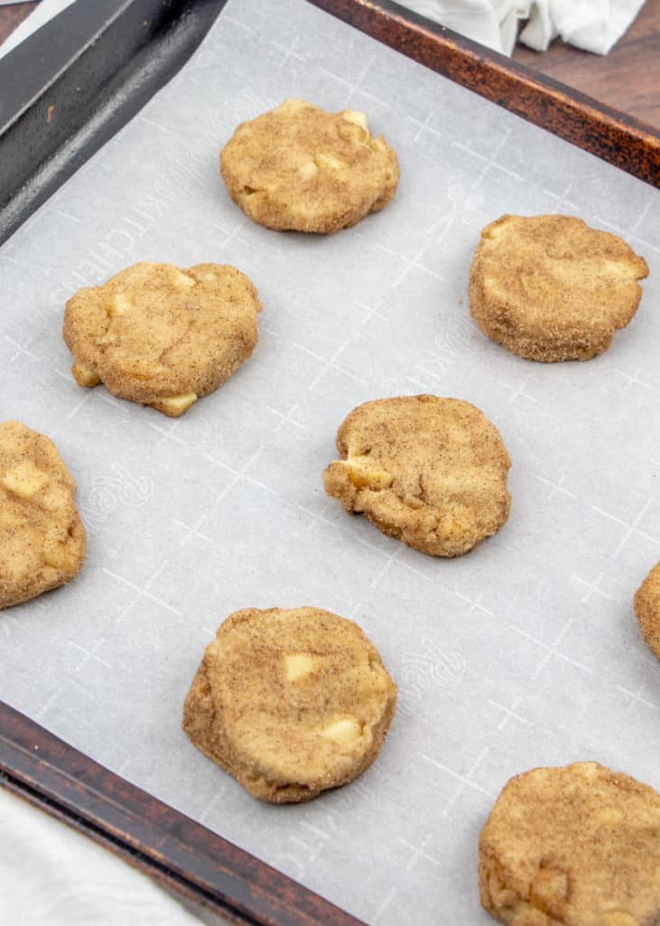 slightly smushed apple cinnamon snickerdoodle cookie batter on a large cookie sheet
