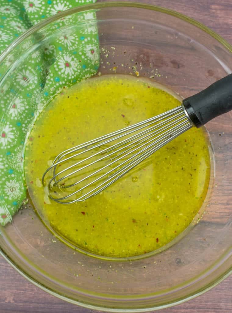 Good Seasonings Italian Dressing prepared in a clear bowl with a whisk.