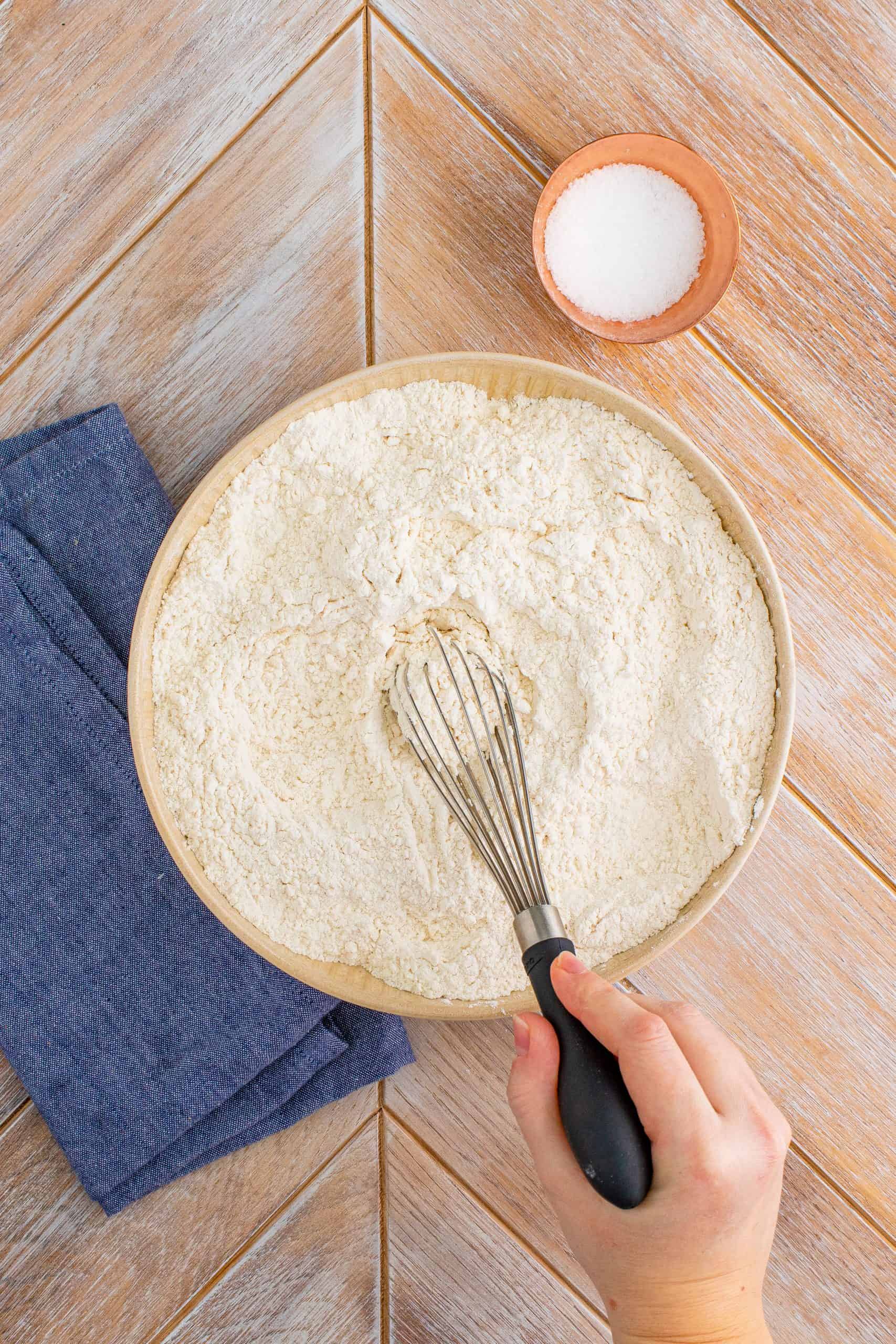 whisking together flour and salt in a bowl.