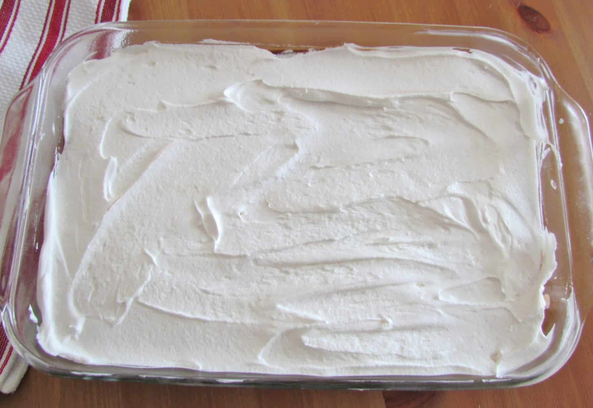 Cool Whip whipped topping spread on top of layered dessert.