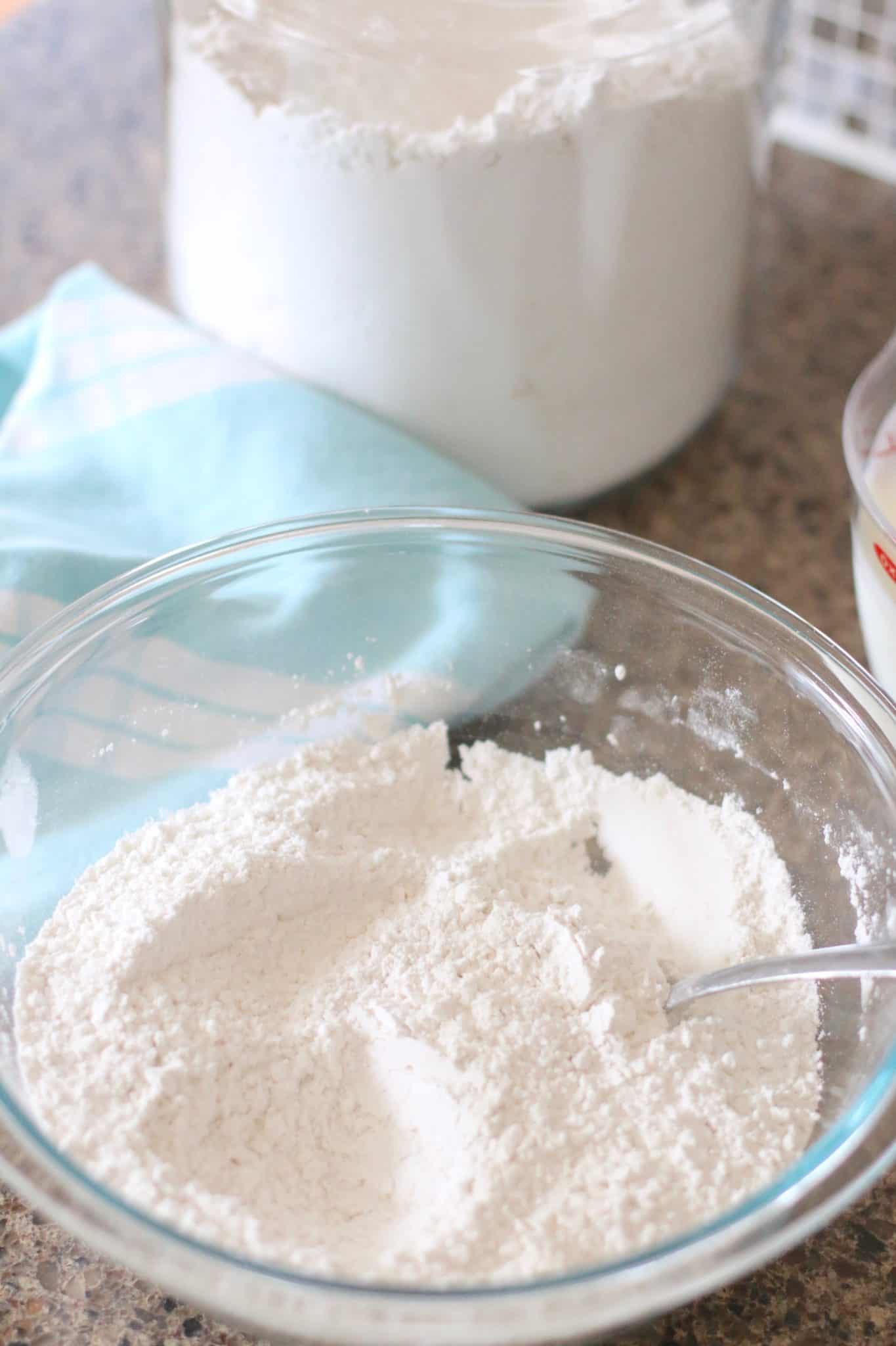 All-purpose flour, baking powder, salt stirred together in a glass Pyrex bowl stirred with a fork.