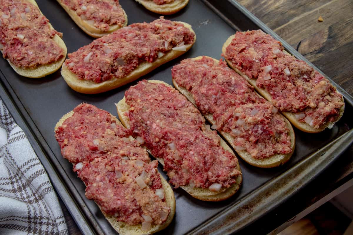 meatloaf mixture spread evenly across on top of sub roll buns.