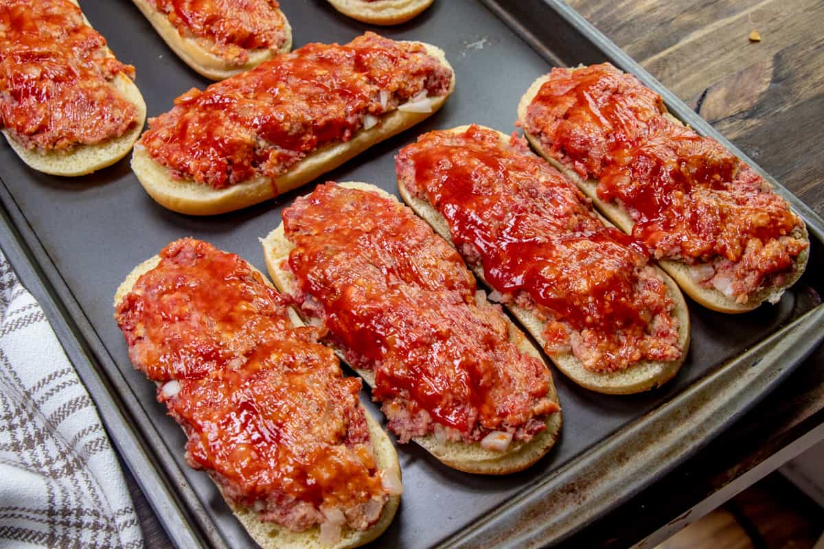 ketchup evenly spread on top of meatloaf mixture on buns.
