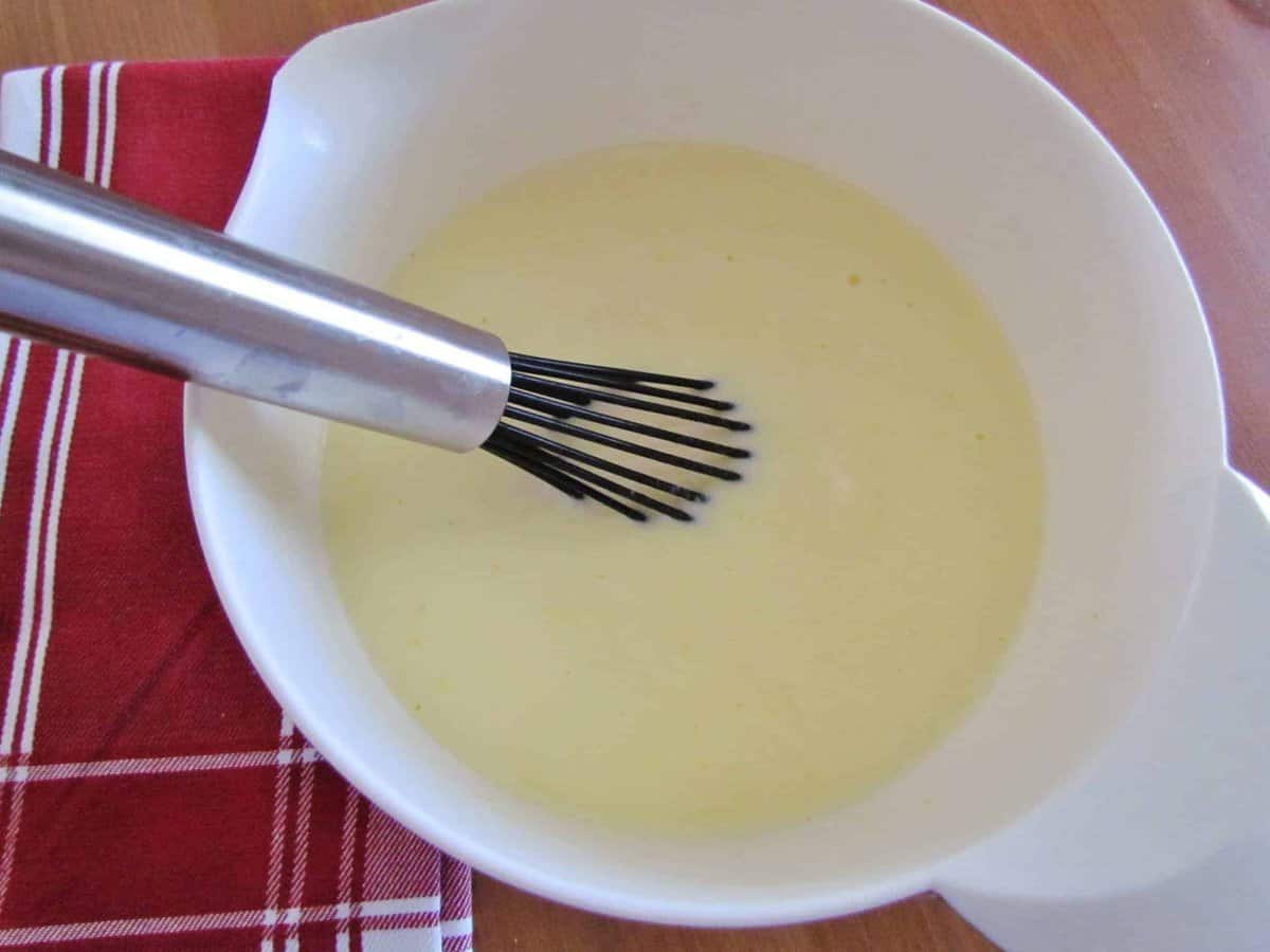 instant vanilla whisked together with milk in a white bowl.