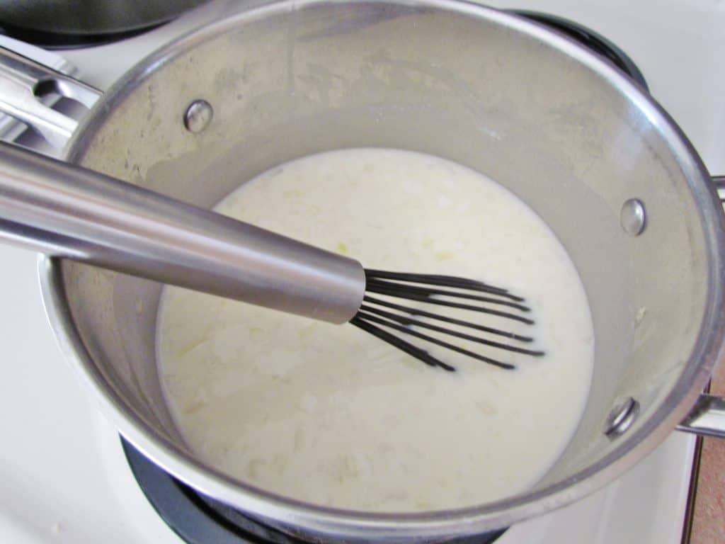 whisking liquid mixture together in saucepan