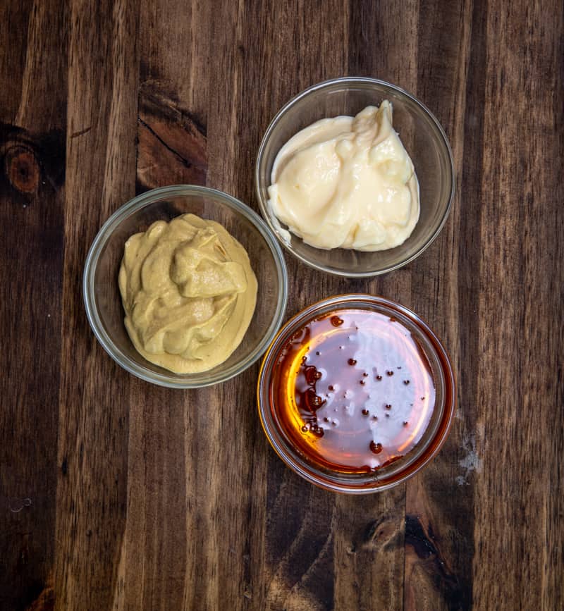 honey, Dijon mustard and mayonnaise shown in  3 small clear bowls. 