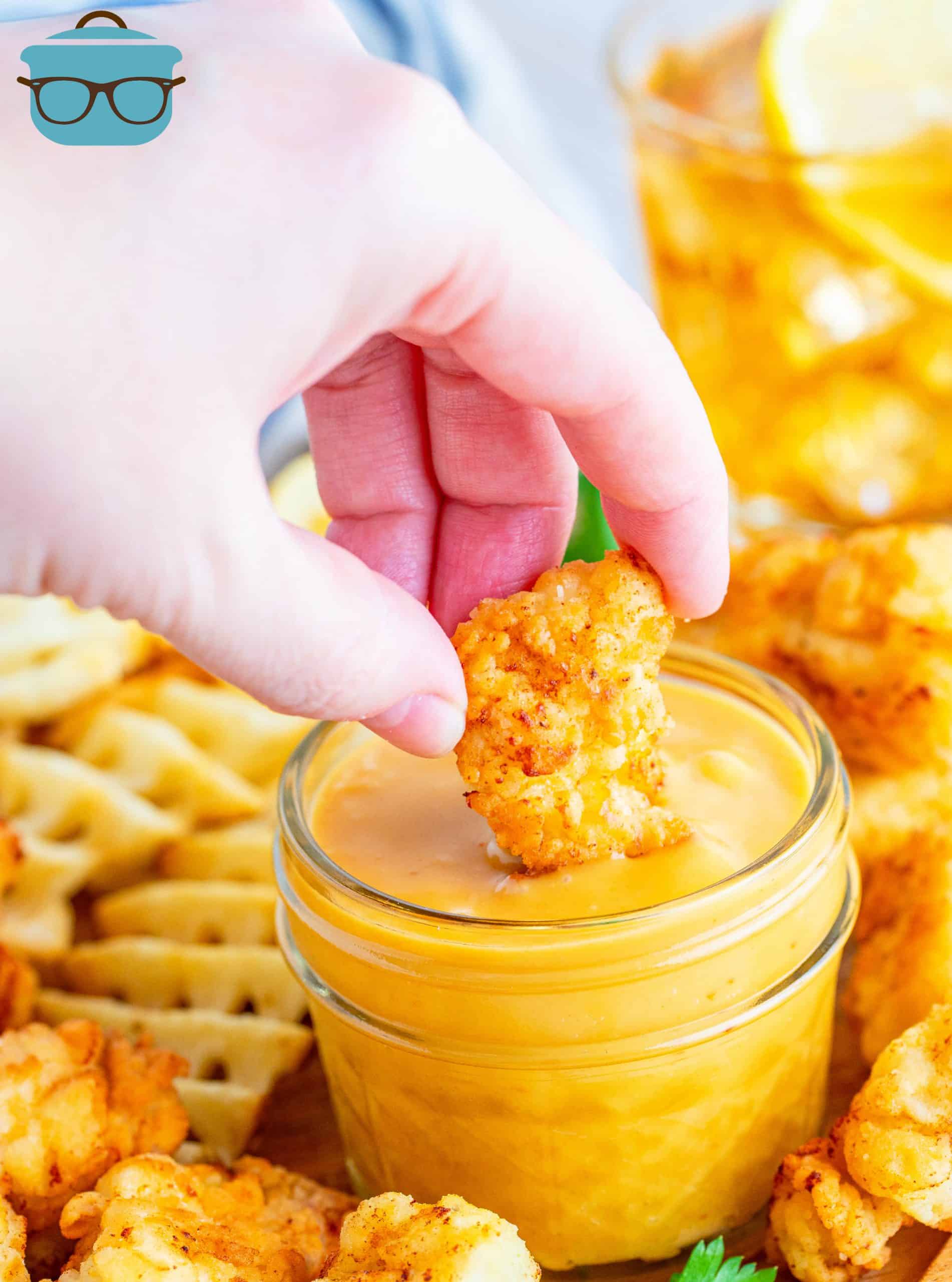 Dipping chicken nuggets into honey mustard sauce.