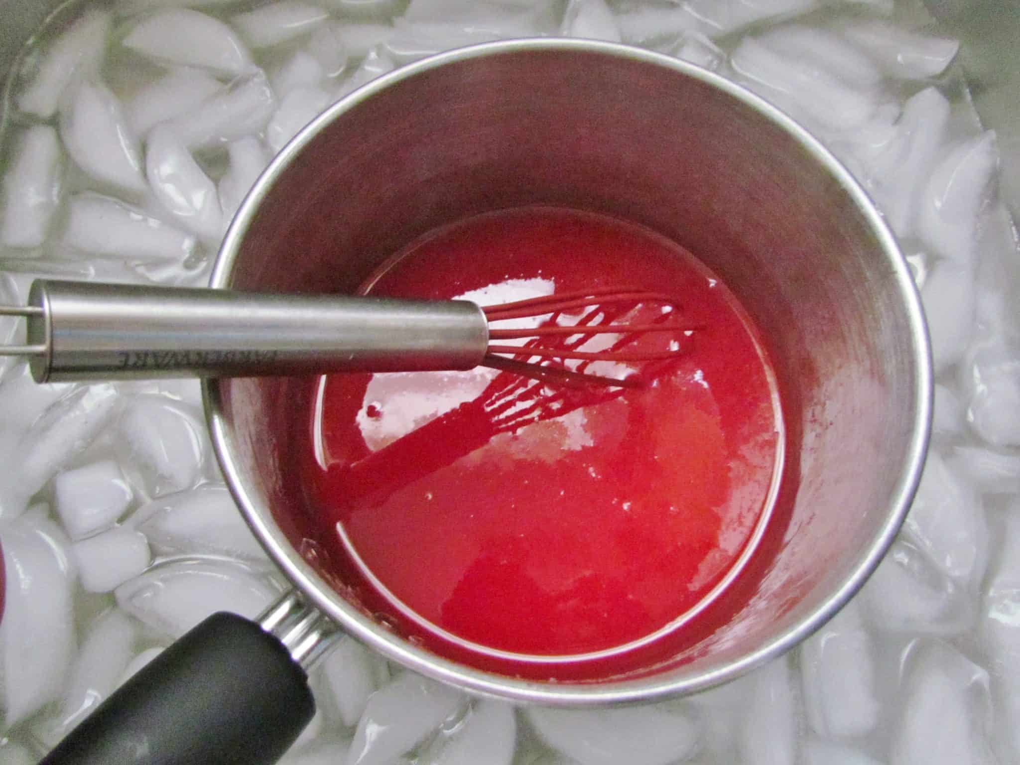 cooled gelatin mixture in a sauce pan shown in an ice water bath.