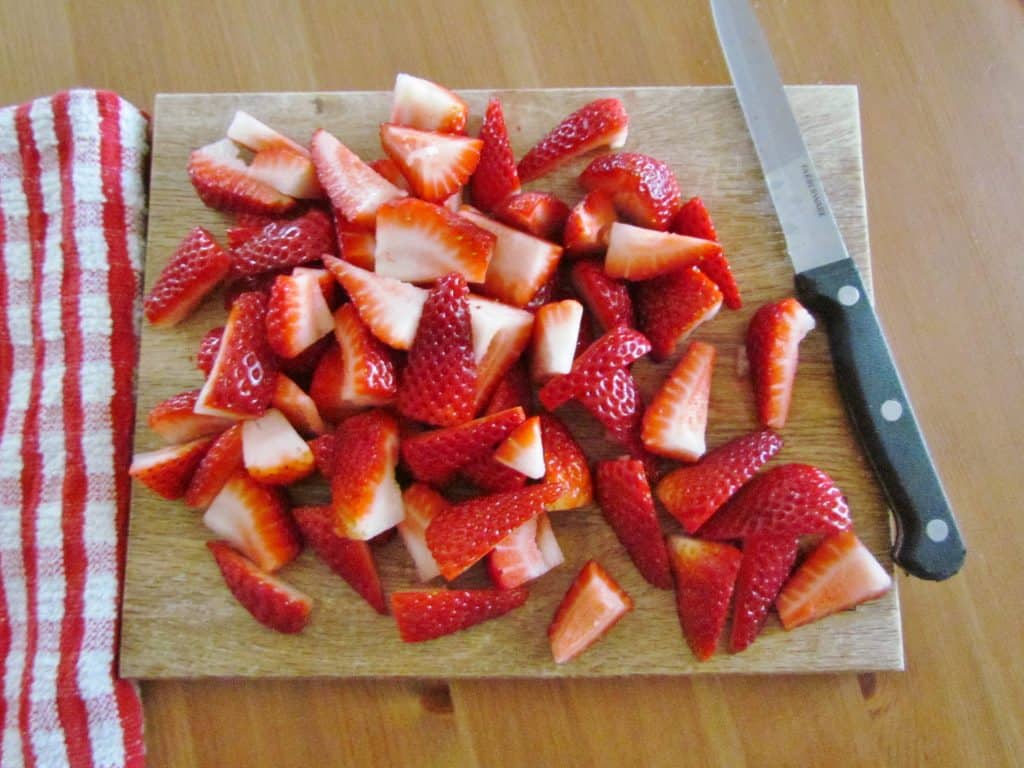 sliced fresh strawberries on a cutting board