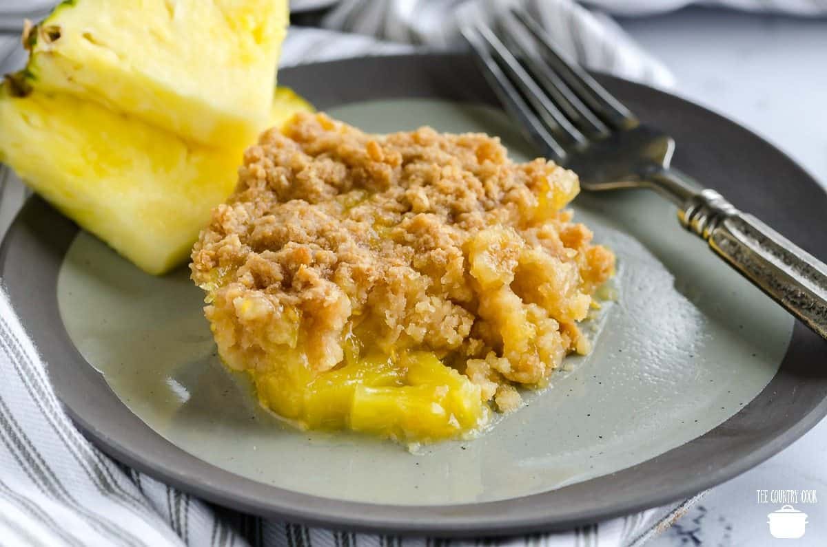 Warm Southern Pineapple Casserole on a plate with fresh pineapple.