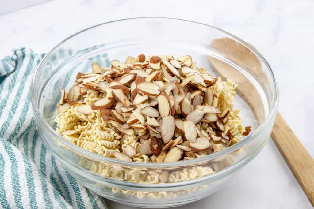 crushed ramen noodles and sliced almonds mixed together in a bowl.
