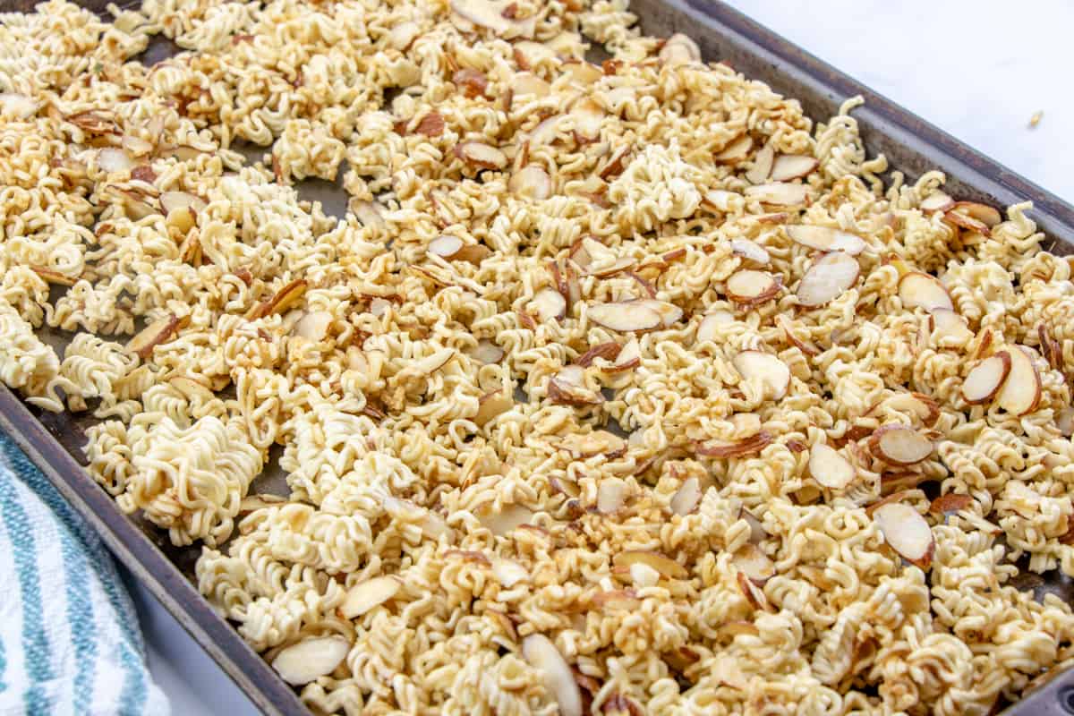 toasted ramen noodles and almonds on a baking sheet.
