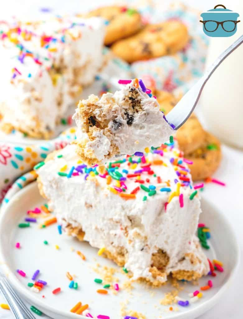 forkful of cookies and cream pie with pie slice in the background and colorful sprinkles