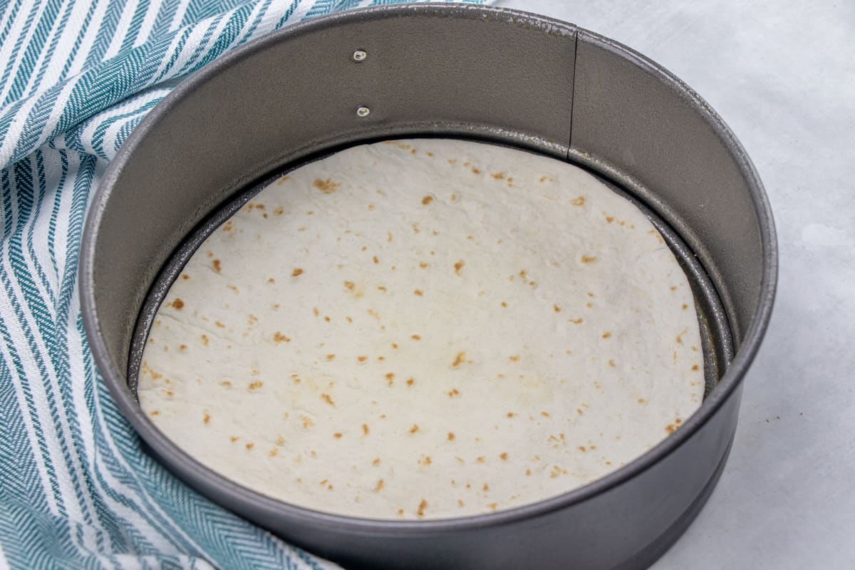 flour tortilla in the bottom of an 8-inch springform pan.