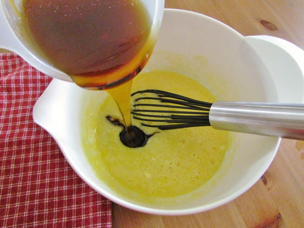 pouring corn syrup into pecan pie batter mix