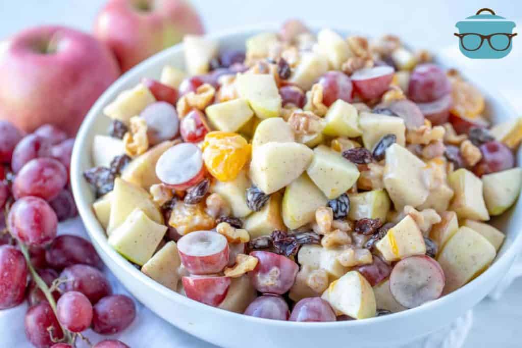 Creamy Cinnamon Apple Fruit Salad in a large bowl displayed with grapes and apples